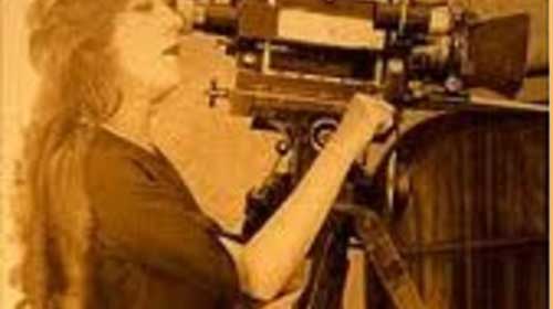 A woman operating a motion picture camera